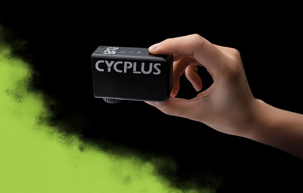 Dłoń pewnie trzymająca czarną, aluminiową pompkę Cycplus AS2 PRO z jasnym logotypem marki na korpusie.